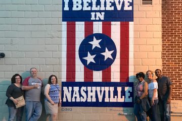 a group of people standing in front of a brick building