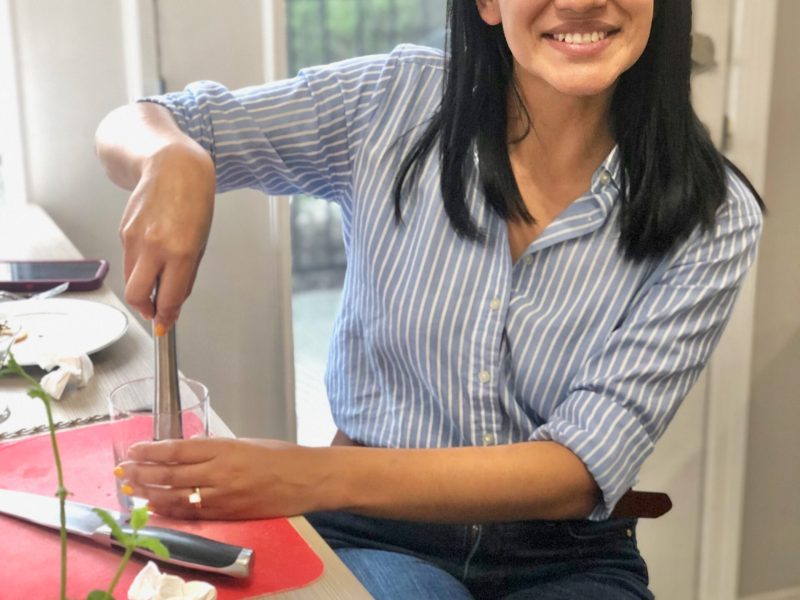 a woman sitting at a table with a knife