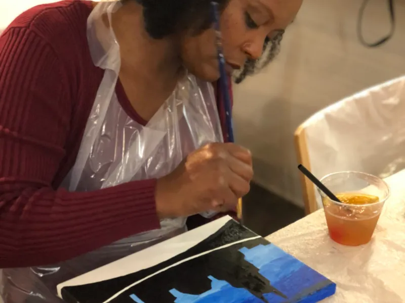 woman painting with a cocktail
