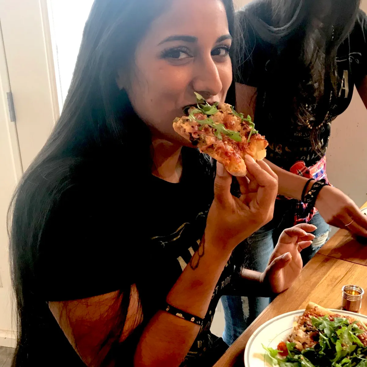 a woman eating a slice of pizza